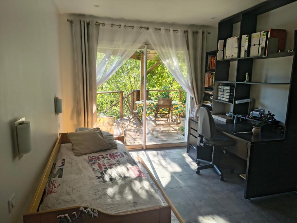 a room with a bed and a desk and a computer at Chambre privative in Lecci