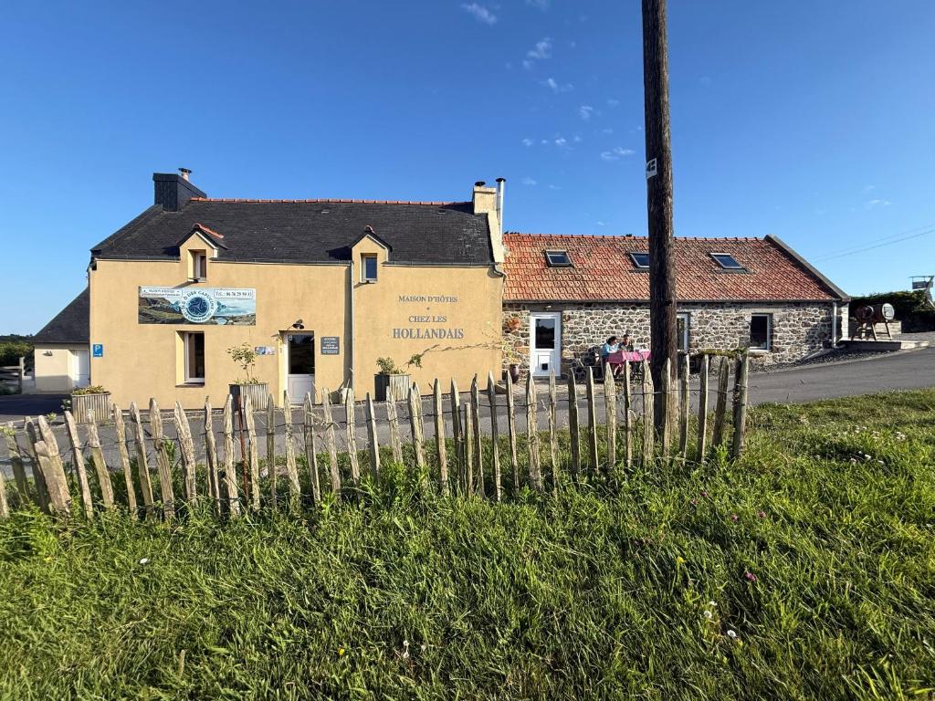 a building with a fence in front of it at Chez Les Hollandais in Roscanvel