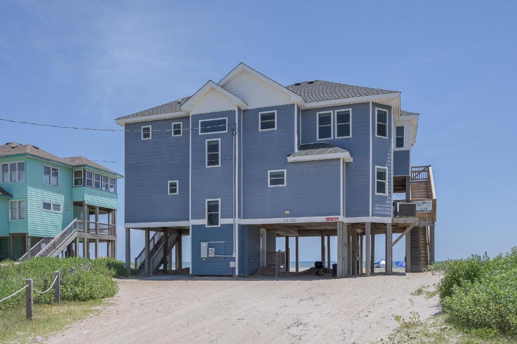 a large blue house sitting on top of a beach at 7048 - Tide Song in Rodanthe
