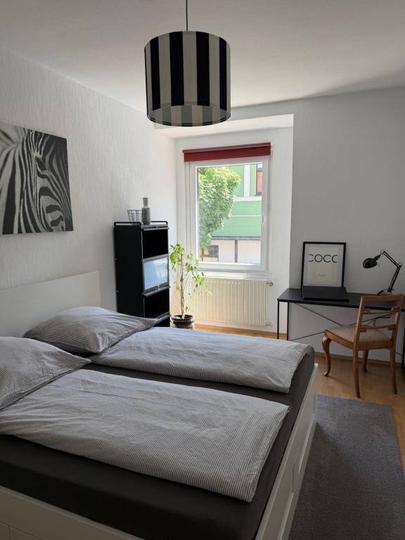 a bedroom with a bed and a desk and a window at Mellow Oak by Interior Apartments - 65qm - 2 Schlafzimmer - Solingen, nahe Köln&Düsseldorf - bahnhofsnah - A1 - Gratis WLAN & TV in Solingen