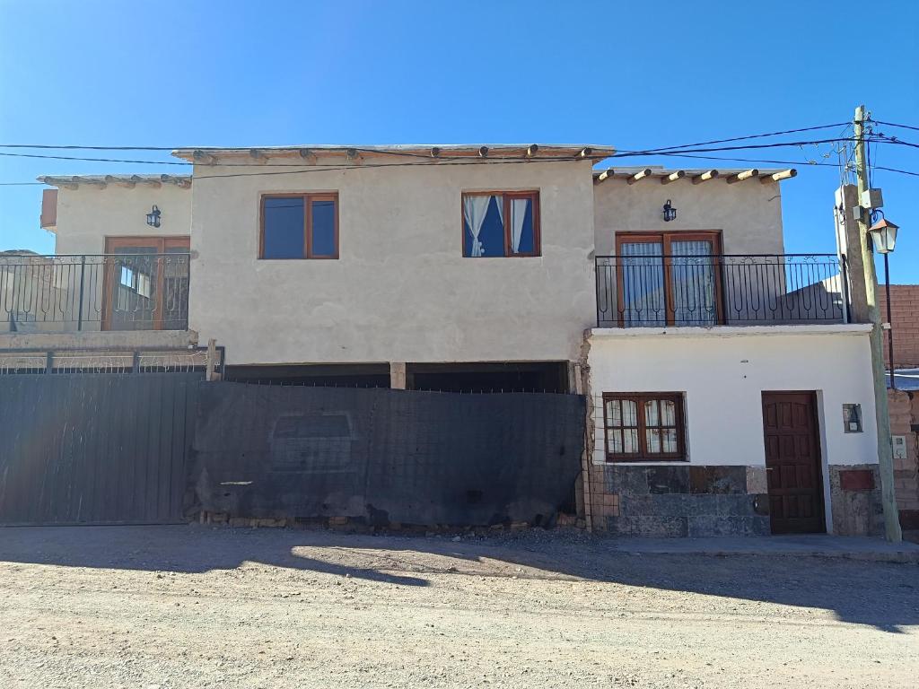 a white house with a fence in front of it at Cabana Mirador Sumajpacha in Tilcara