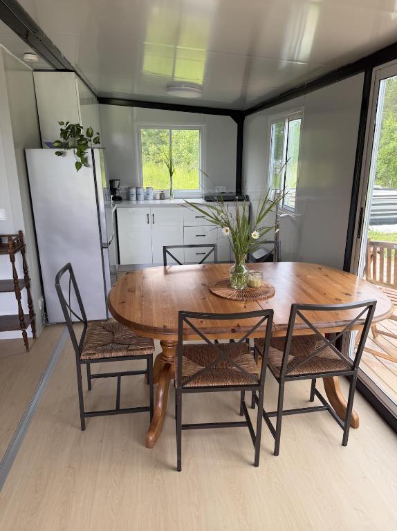 a dining room with a table and chairs and a kitchen at Peppa Puhkemaja in Vahtrepa