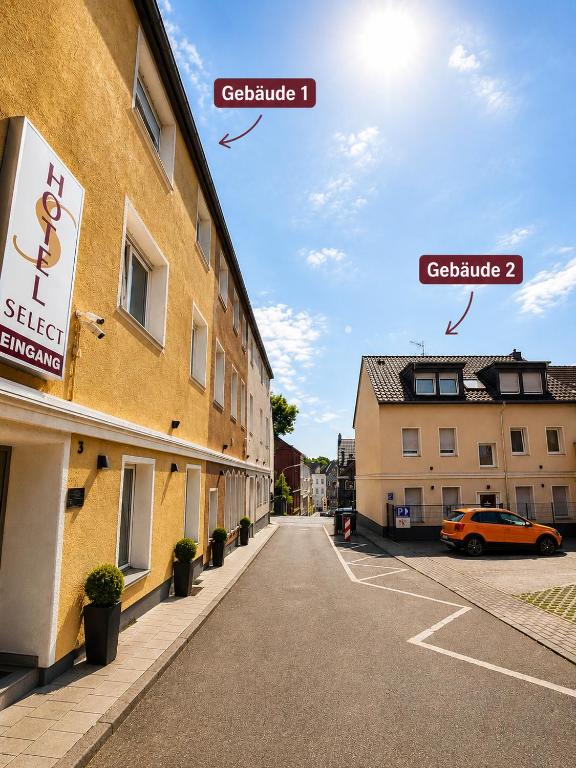 ein Gebäude mit einem auf einem Parkplatz geparkten Auto in der Unterkunft WOS Hotel in Mönchengladbach