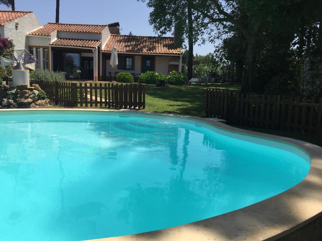 a large blue swimming pool in front of a house at Rustic Villa with Private Pool near Ericeira in Mafra