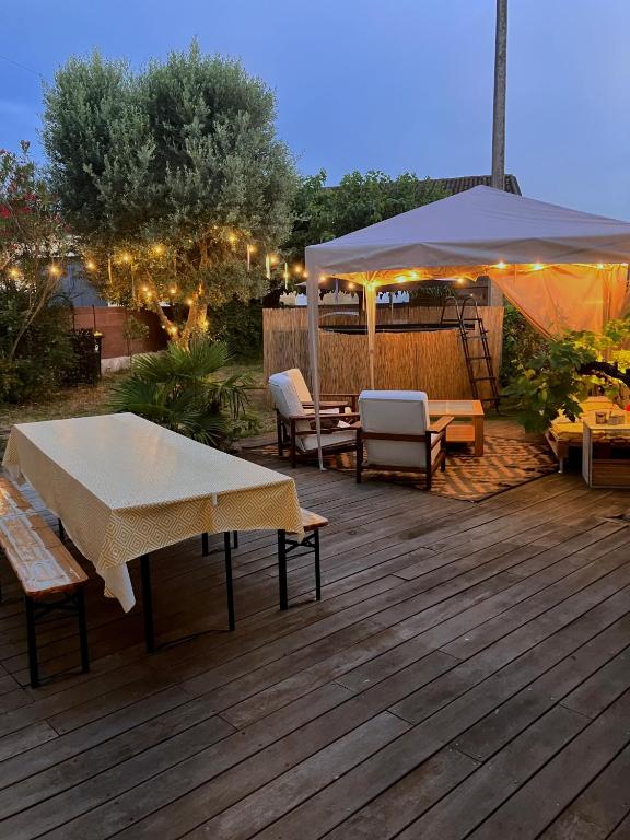 a deck with a table and chairs and an umbrella at Amis Wine House - Maison d'hôtes à 5 min de Saint-Émilion in Pomerol