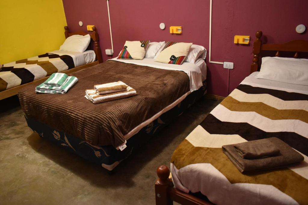 a room with two beds with towels on them at Kamaq Hostel in Humahuaca