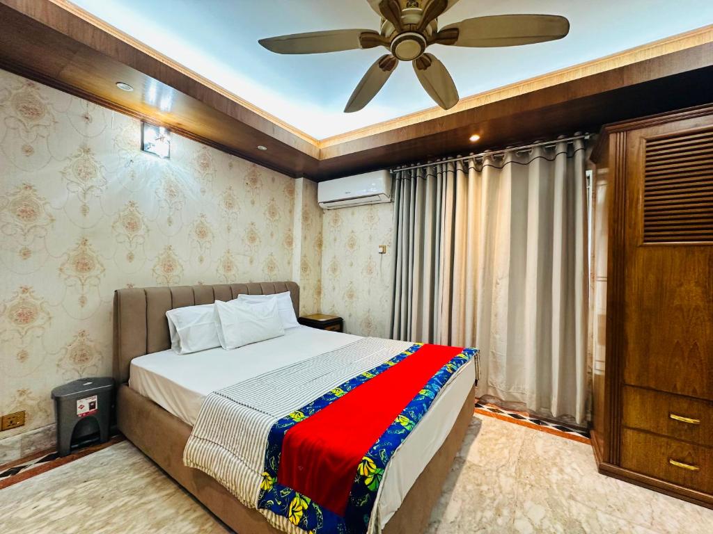 a bedroom with a bed and a ceiling fan at Sea Shell Service Apartment in Bāiljuri