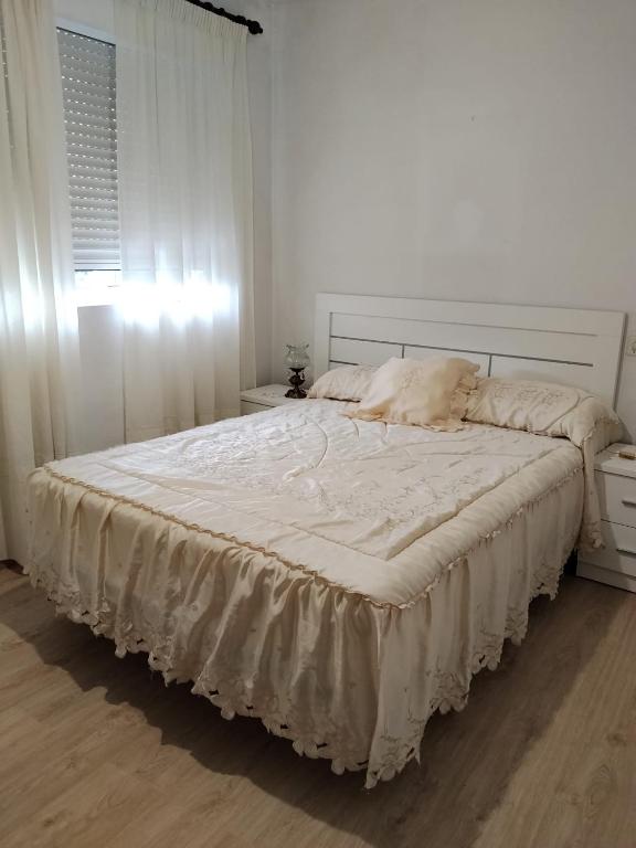 a bedroom with a large bed with a white bedspread at O Recuncho da Xunqueira in Viveiro