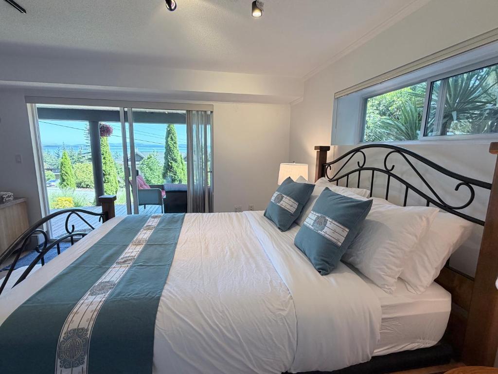 a bedroom with a large bed with a large window at Cozy Ocean View Retreat in Victoria