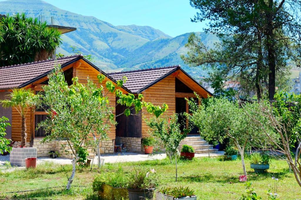 a log cabin with mountains in the background at Bujtinat e Delvinës in Delvinë