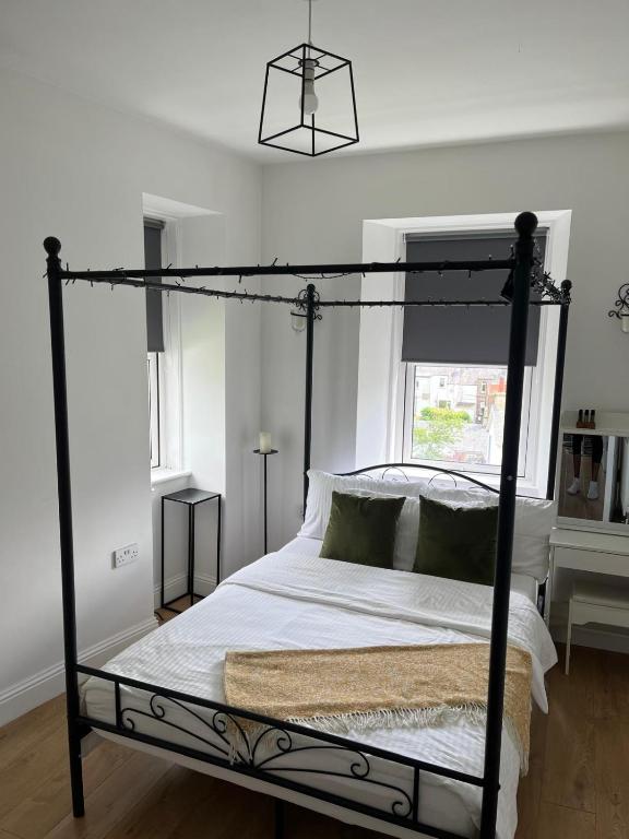 a bedroom with a black canopy bed with white sheets at The Nook Dunblane in Dunblane