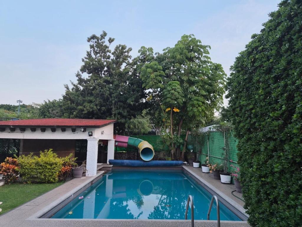 a swimming pool with a slide in a yard at Cocoyoc Residential Estate in Texcalpan