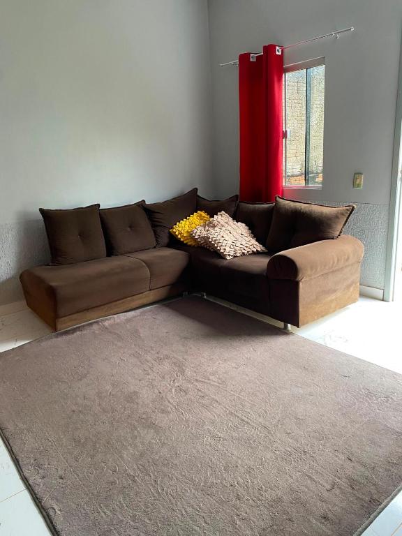 a brown couch in a living room with a red window at Studio Brasiléia in Brasiléia