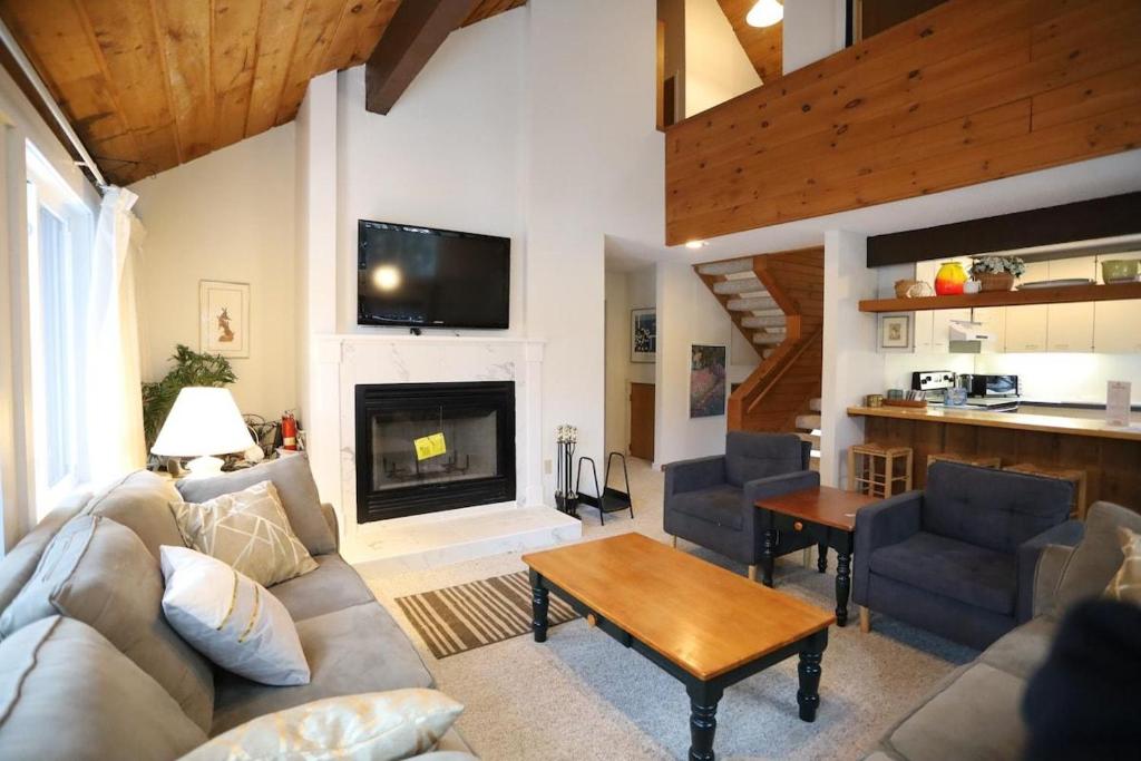 a living room with a couch and a fireplace at Sunnyside 6 in Condo Waterville Valley in Waterville Valley