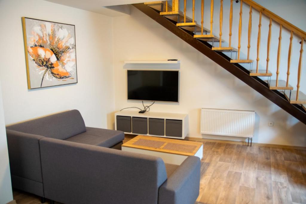 a living room with a couch and a flat screen tv at Apartmán Cukrárna in Mladá Vožice
