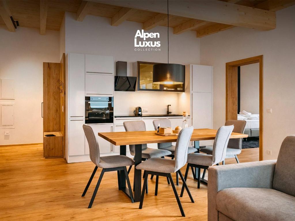 a kitchen and dining room with a wooden table and chairs at CHEZ NOUS - Balcony & Mountain View in Fügen