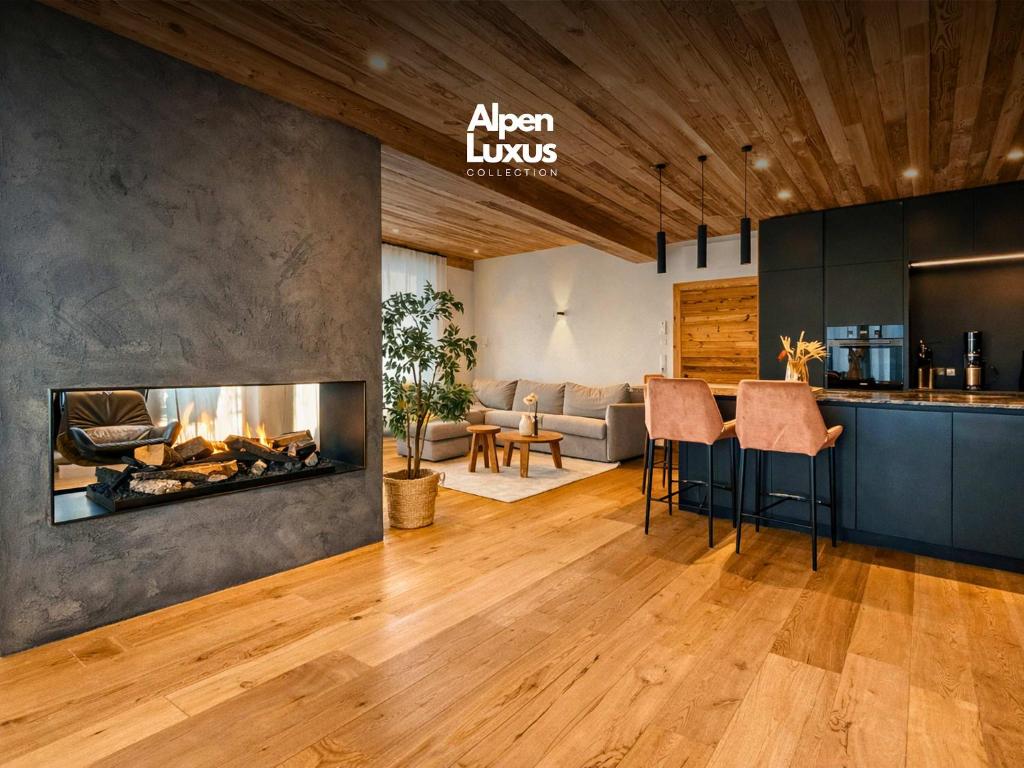 a living room with a fireplace and a kitchen at CLOUD 9 - Private Whirlpool & Rooftop Terrace in Fügen