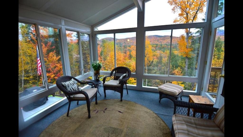 a living room with a table and chairs and windows at Welch View 68 Thornton Deluxe Private 4 Bedroom Home in Thornton