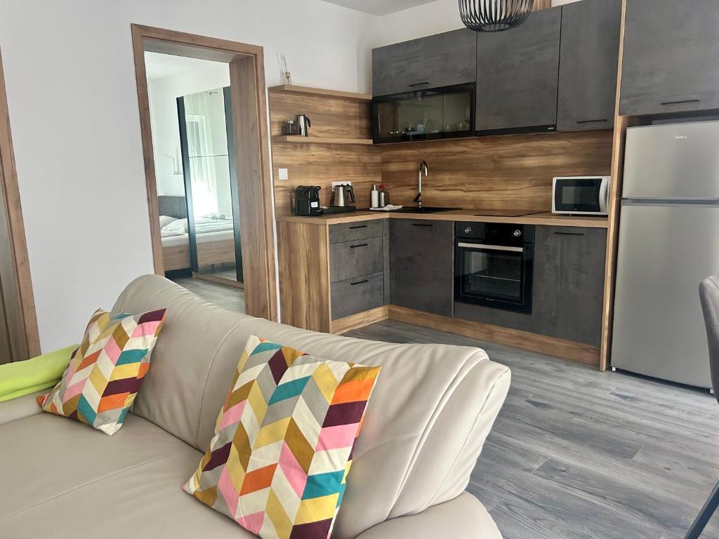a living room with a couch and a kitchen at iHome Apartman 4 in Pécs