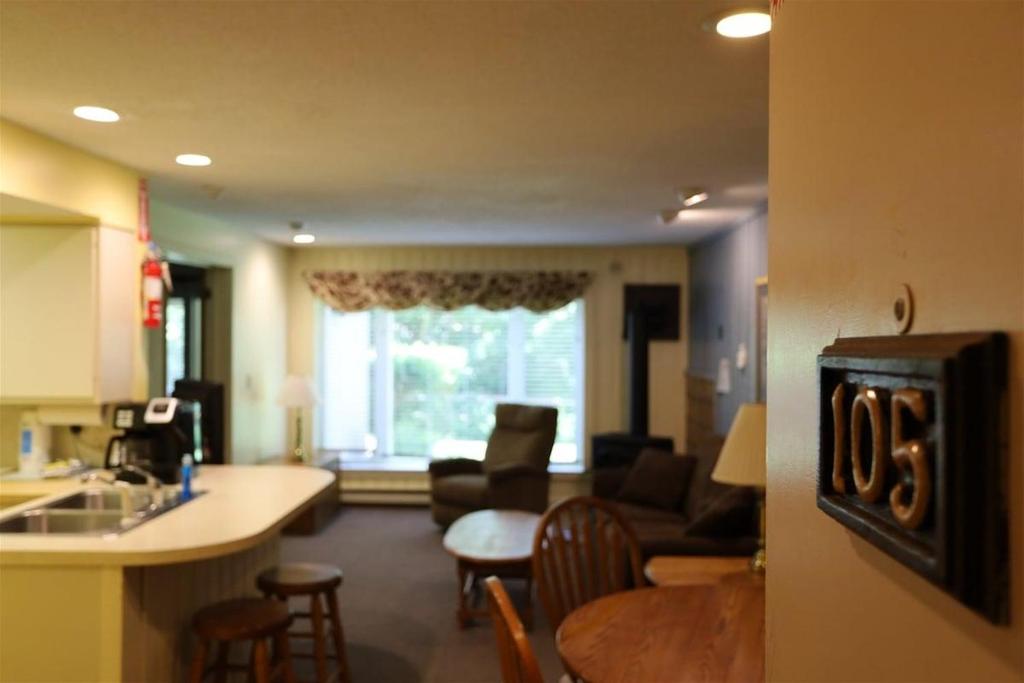 a kitchen and living room with a couch and a table at Inns of Waterville Valley 105 One Bedroom Garden Level Unit at Inns of WV in Waterville Valley