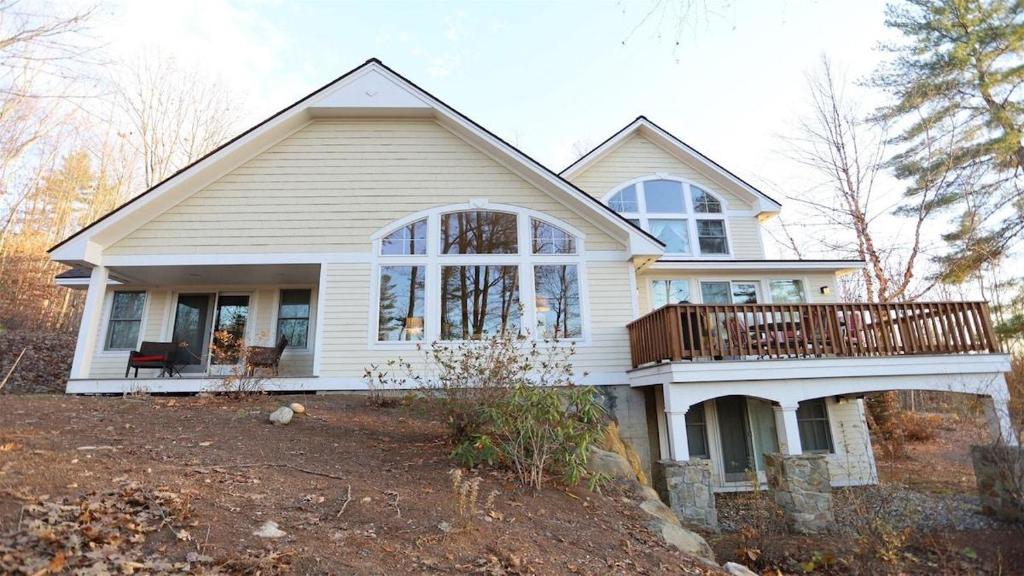 a white house with a porch and a balcony at Rising Ridge 28 Owls Nest Deluxe Pet friendly Home at Owl`s Nest in Campton