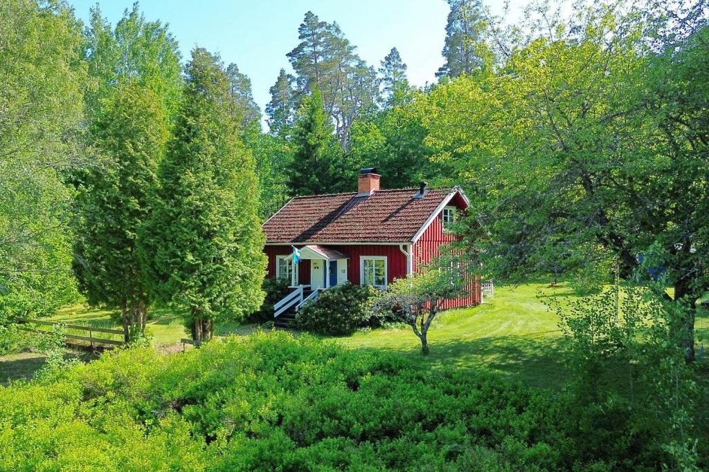 a red house in the middle of a forest at "Tuna Sol" in Vimmerby
