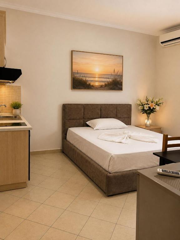 a bedroom with a bed and a painting on the wall at Vila Mare in Shëngjin