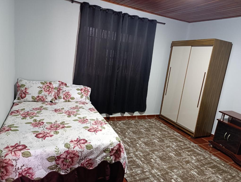 a bedroom with a bed and a dresser and a window at cantinho da paz in Dourados