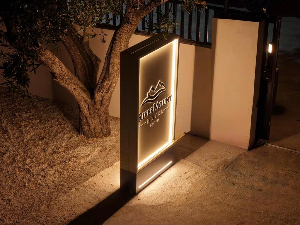 a sign on the side of a building at night at RiverMount Hotel Borsh in Borsh
