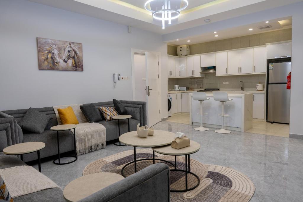 a living room with a couch and tables and a kitchen at The view apartment 2 in Al Baha
