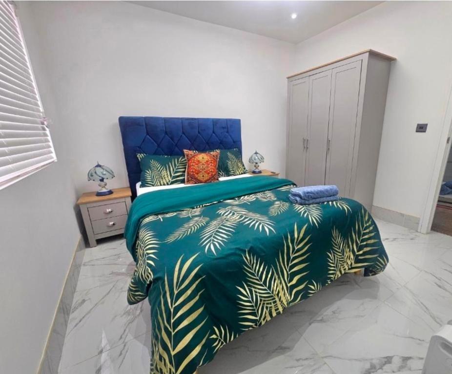 a bedroom with a large bed with a blue headboard at Heaven in Sutton