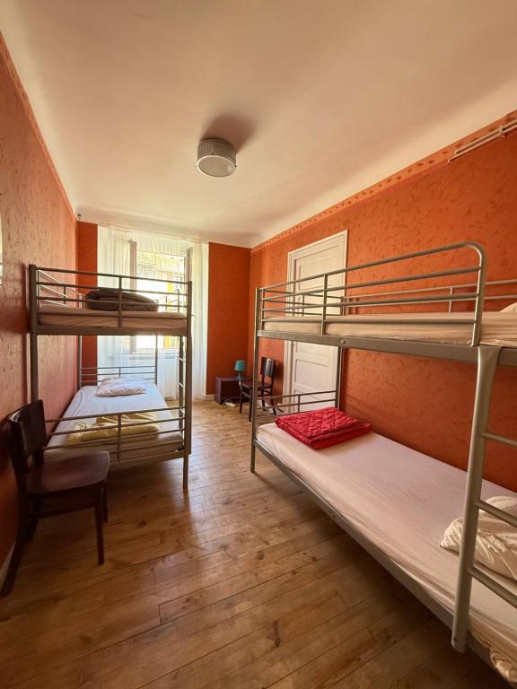 a room with two bunk beds and a chair at Le Kompost'l dortoir en gîte 4 place in Saint-Privat-dʼAllier