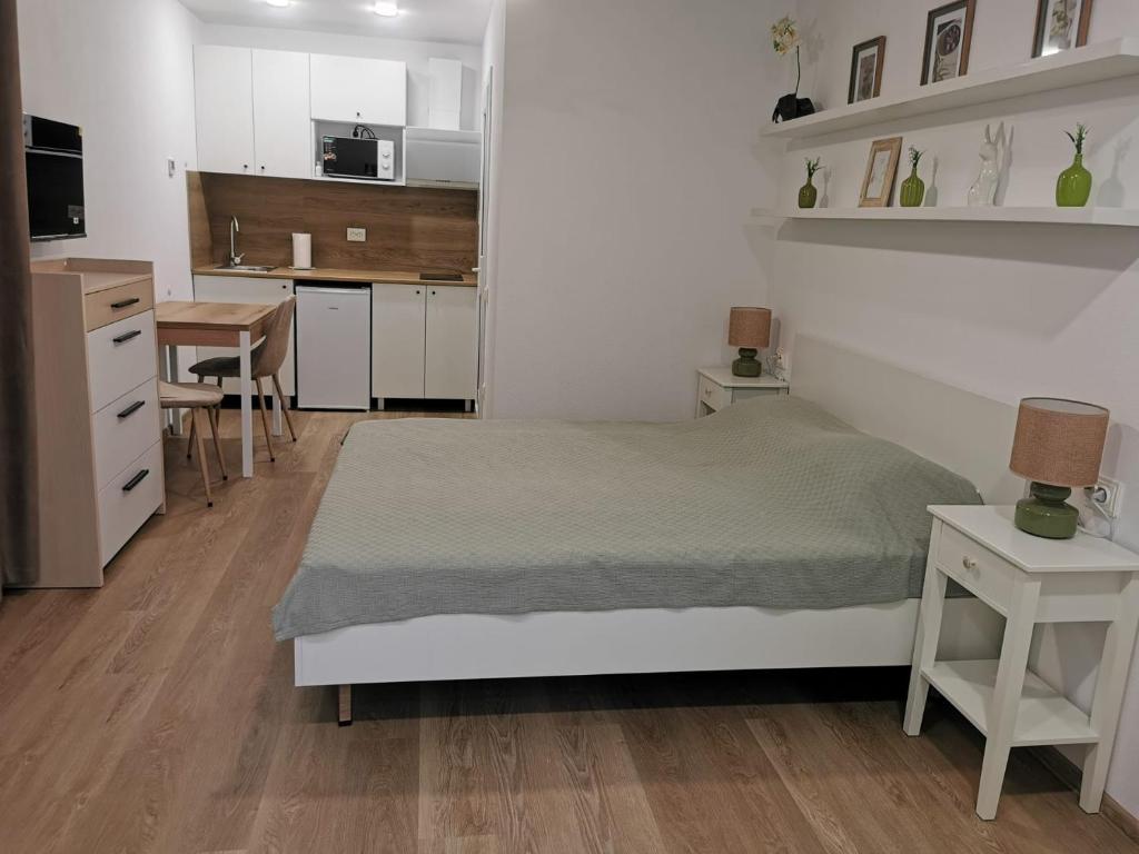 a bedroom with a bed and a table and a kitchen at Happy Home1 in Cahul