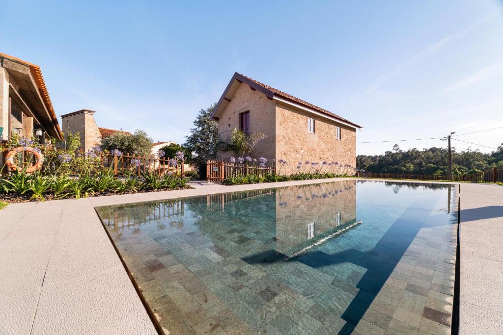 an image of a swimming pool in front of a house at RioVerde Agroturismo in Barcelos