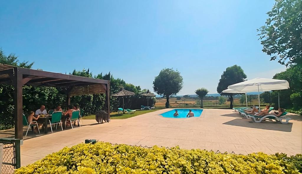 a group of people sitting around a swimming pool at Can Micos - Masía de grupos 16 hasta 25 personas in Riudarenes