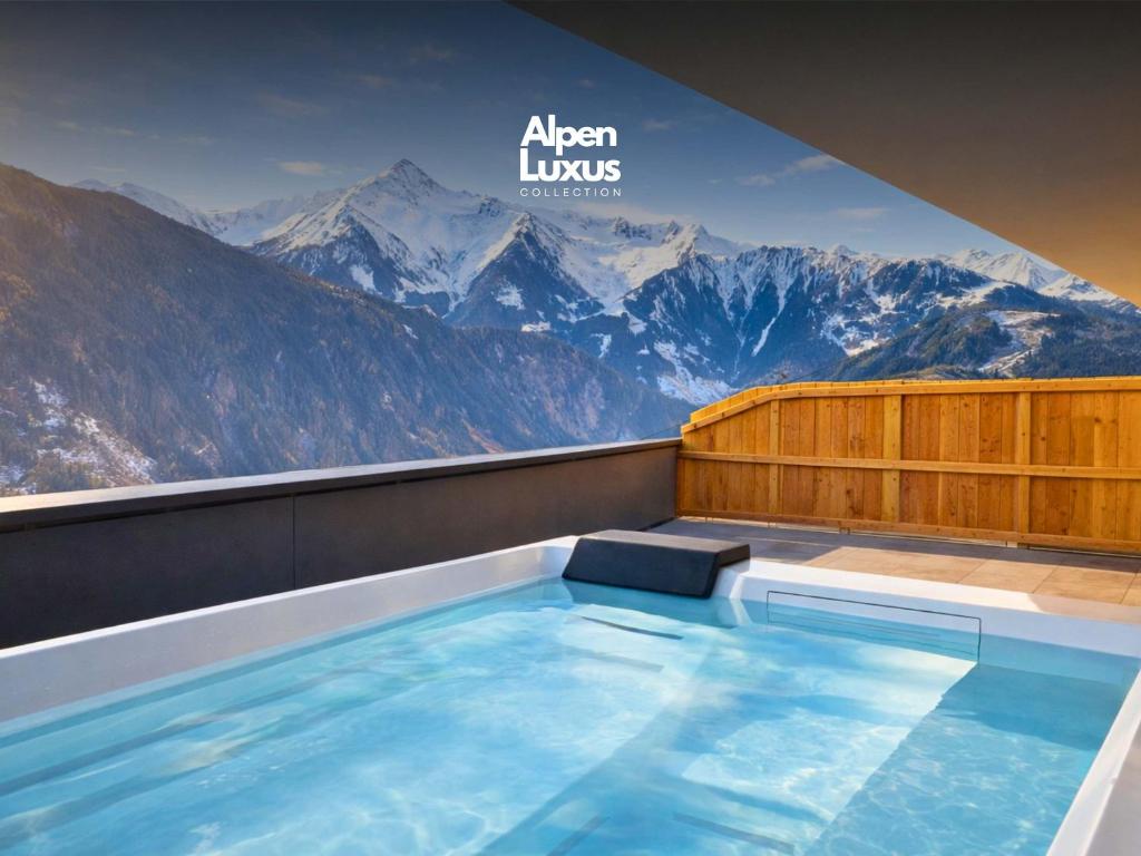 a hot tub with a view of mountains at SKYLINE Chalet - Two-Level Penthouse with Private Whirlpool in Mühlen