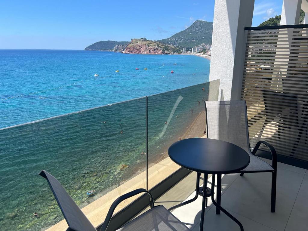 a table and chairs on a balcony with a view of the ocean at Hotel Sutomore & Apartments in Sutomore
