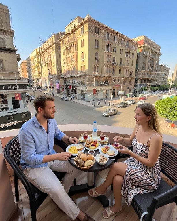 a man and woman sitting at a table with food at The Rivénto Boutique with Breakfast - Downtown,Cairo in Cairo