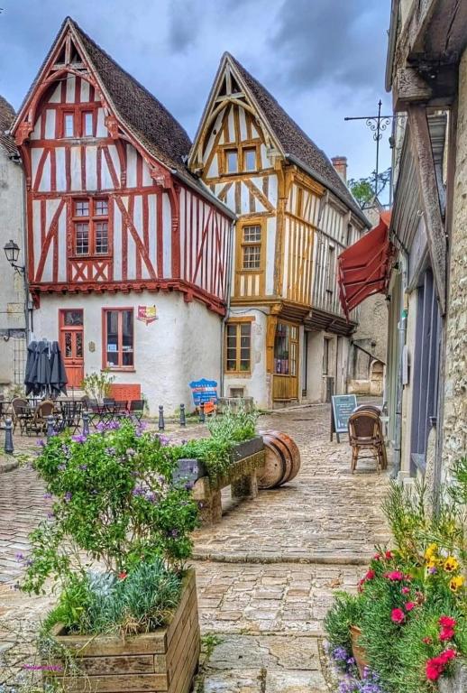 a group of half timbered houses in a courtyard at La petite maison d'à côté in Noyers