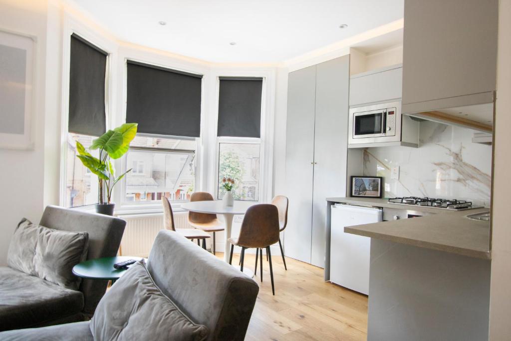 a kitchen and living room with a couch and a table at Best in Class - London, Harrow in Harrow