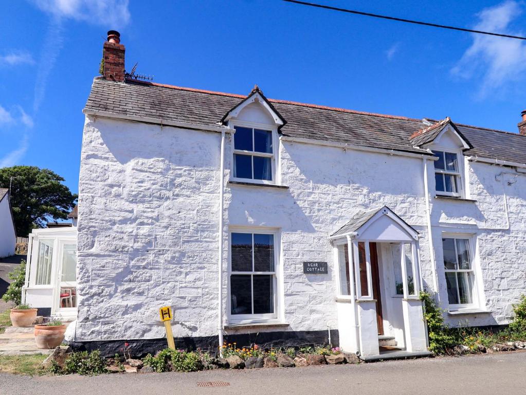 a white house with a chimney on top of it at Agar Cottage in Port Isaac