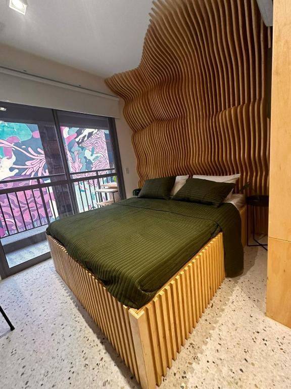 a bedroom with a large bed with a wooden headboard at U House in São Paulo