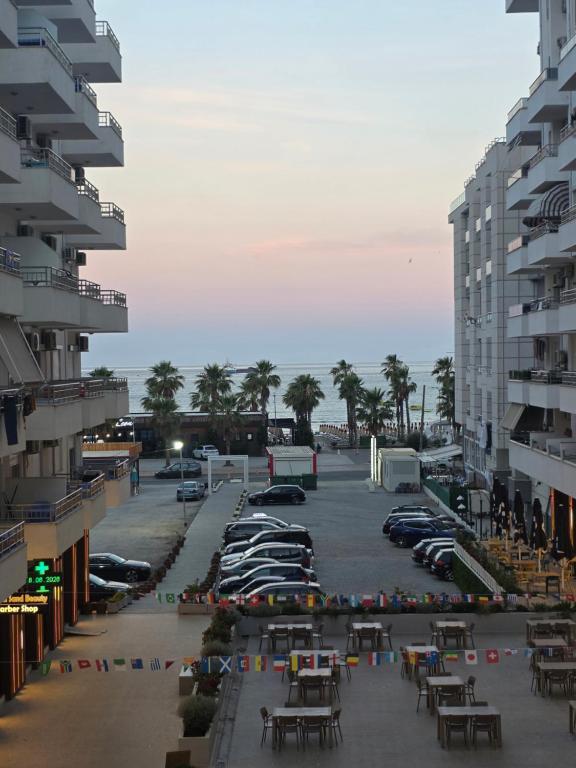 a parking lot with cars parked next to the ocean at Solei Sea Apartment in Shëngjin