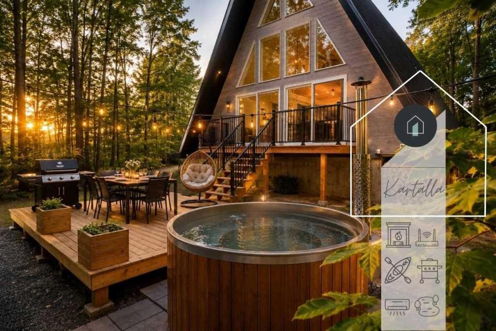 a house with a hot tub in front of it at Kartalla - the A frame experience in Tremblant in Saint-Rémi-dʼAmherst