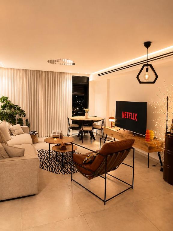 a living room with a couch and a table at amor premium residence-4BR apartment with balcony in Beer Sheva