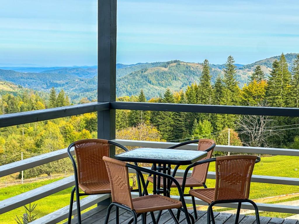 a table and chairs on a porch with a view of mountains at Будиночки Ґалєрія in Vaydry