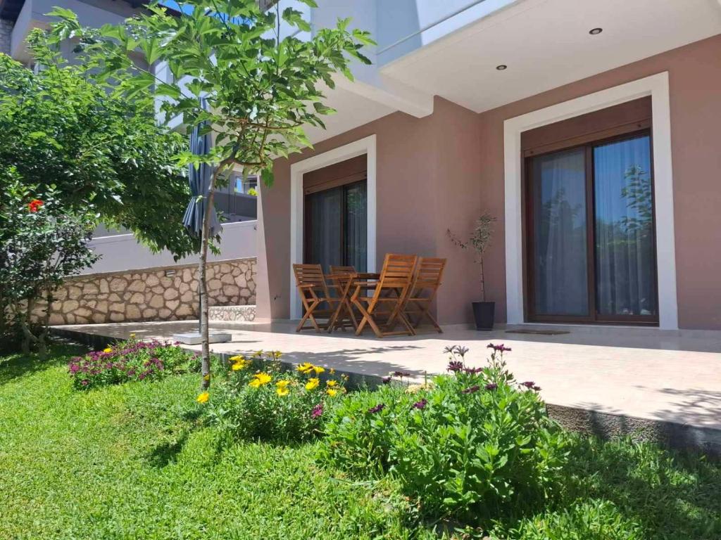 a patio of a house with chairs and flowers at Rhodes Soul Luxury Home in Asgourou