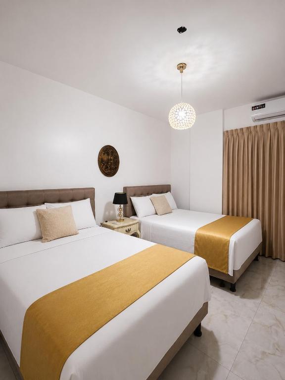 two beds in a hotel room with two beds at Hotel The Royalty Inn in Guayaquil