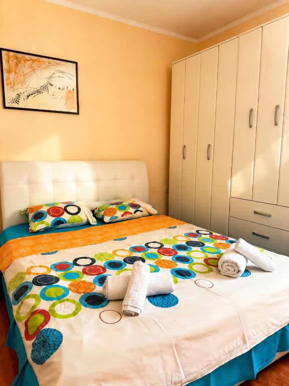 a bedroom with a large bed with a colorful blanket at Apartmani VV in Cetinje