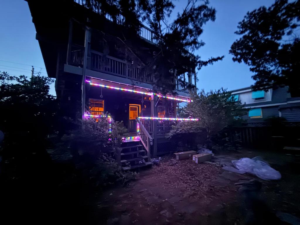a house with christmas lights on it at night at DiscoCat Studios in Ocracoke